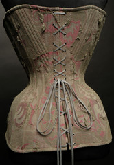 Closeup of vintage female corset on dark studio background