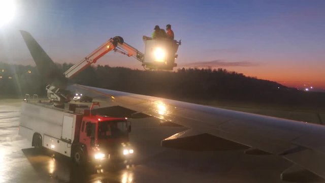Aircraft De-Icing by Airport Ground Crew in De-Icing Truck at Dawn