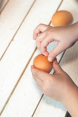 5 years old child cleans the shell of the Easter egg. A little boy cleaning eggs