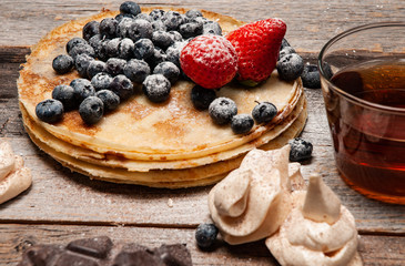 Healthy breakfast, tea and homemade pancakes with fresh berries on wooden table