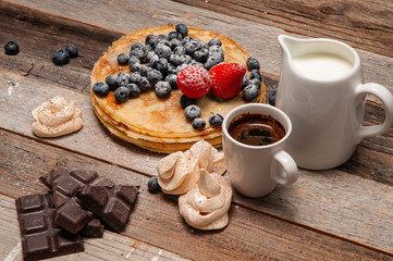 Fototapeta na wymiar Healthy breakfast, coffee and homemade pancakes with fresh berries on wooden table