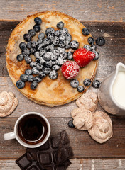 Healthy breakfast, coffee and homemade pancakes with fresh berries on wooden table
