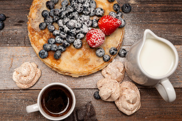 Healthy breakfast, coffee and homemade pancakes with fresh berries on wooden table