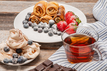 Healthy breakfast, black tea and homemade pancakes with fresh berries on wooden table