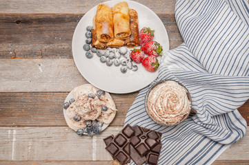 Healthy breakfast, coffee and homemade pancakes with fresh berries on wooden table