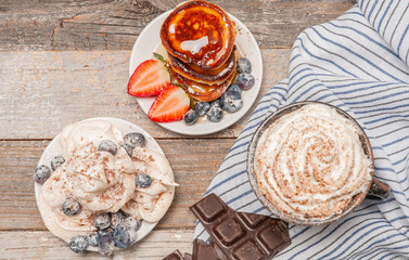 Healthy breakfast. Coffee and delicious pancakes, with fresh berries on wooden table