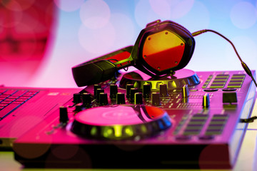 Headphones placed on DJ Mixer in the Nightclub.