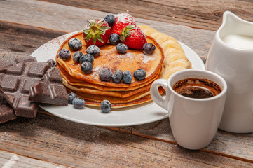 Healthy breakfast, coffee and homemade pancakes with fresh berries and banana