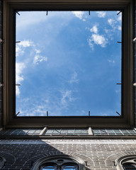 Window to the sky. View upstairs from courtyard of vintage house in Florence, Italy. Very interesting angle. Square frame with falling sun rays.