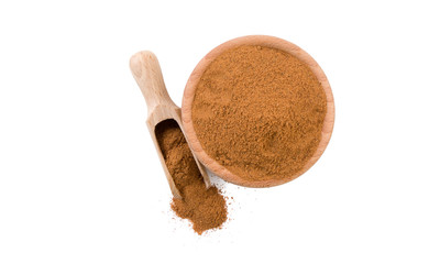 milled or ground nutmeg in wooden bowl and scoop isolated on white background. top view. Spices and...
