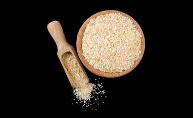 dried onion in wooden bowl and scoop isolated on black background. top view. Spices and food ingredients.