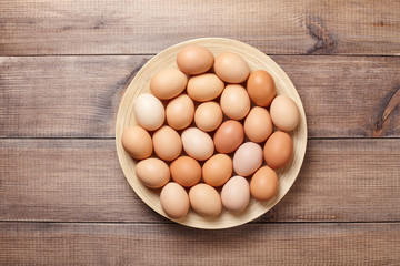 Eggs in the plate on wooden table. Top view.