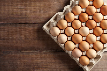 A pack of eggs on wooden table. Top view.