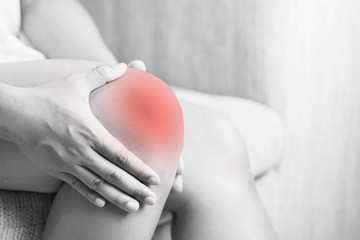 Bone pain or knees around the knee , The girl's hand is holding the knee area.