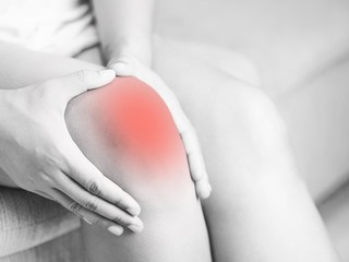 Bone pain or knees around the knee , The girl's hand is holding the knee area.