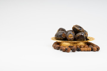Dates and Rosary on white background with selective focus and crop fragment. Ramadan, Religion and Copy space concept. Black and White
