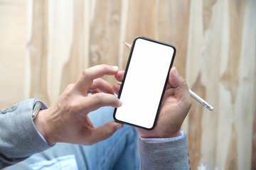 Man using mobile smartphone at wood table