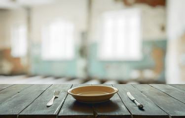old wooden table in room with big windows
