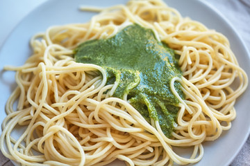 spaghetti and pesto sauce are on the plate