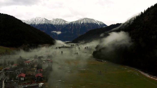 Morning fog taking over a small village in the mountains. 4K shot.