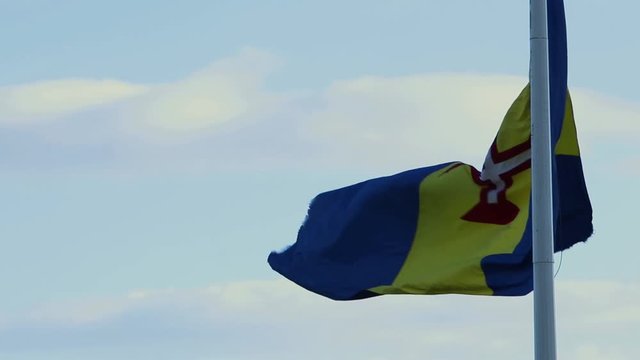 The national flag of the Autonomous Region of Madeira Island in the wind on a clear blue sky day