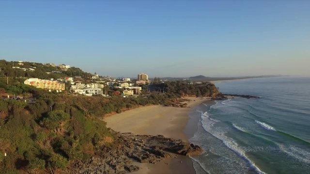 Aerial drone shot over the coastline towards the community of Coolum