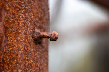 Rusty corroded fixing on iron gate post to farmland with shallow depth of field