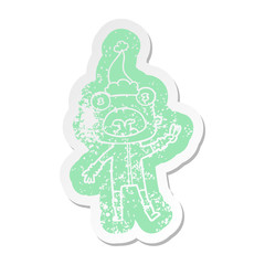 cartoon distressed sticker of a weird alien waving wearing santa hat