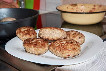 fried finished meat patties on a white plate standing on a table on a white towel. homemade fresh hearty wholesome food. cooks food at home.
