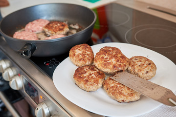 fried cooked meat patties from pork beef and chicken on a white plate standing on a table on a white towel on top of a spatula for cooking. homemade fresh hearty wholesome food. dinner.