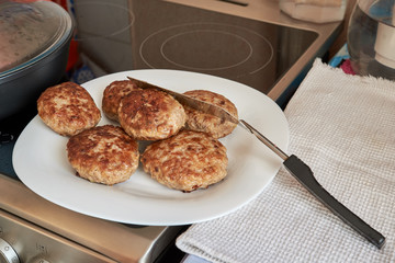 fried finished meat patties on a white plate standing on a table on a white towel. homemade fresh hearty wholesome food. cook cooks food at home. dinner.