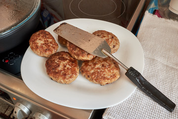 fried cooked meat patties from pork beef and chicken on a white plate standing on a table on a white towel on top of a spatula for cooking. homemade food. prepares food at home. dinner.