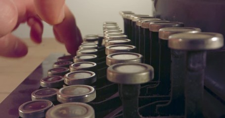 Special macro dolly shot hovering over old typewriter keys with male hand typing