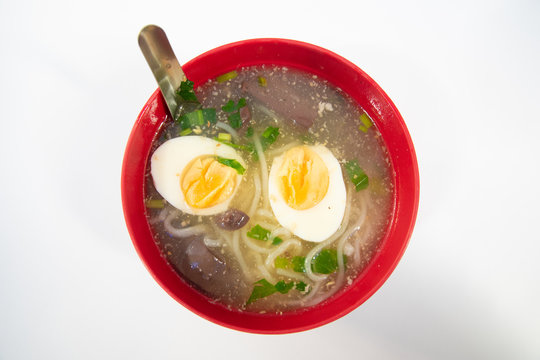  Paste of rice flour is in a red cup with eggs and vegetables as an appetizing component.