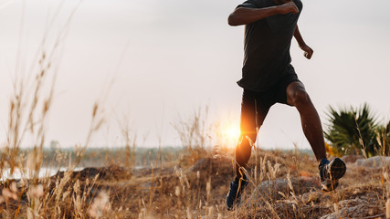 Image of Athlete trail running, runner running on hill.