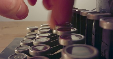 Special macro dolly shot hovering over old typewriter keys with male hand typing