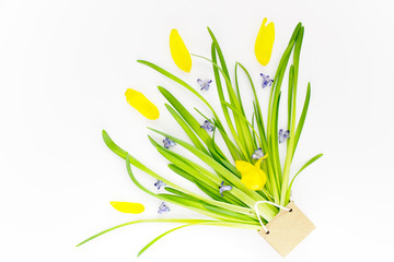 Flower composition in the form of an improvised bouquet of greenery, yellow tulips and petals in a small paper bag. Can be used for birthday, mother's day. Concept, flat lay, top view, copy space, 