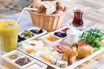 Traditional Turkish Breakfast with various jams, cheeses, olives, beverages and pastry 