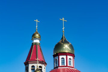 The domes of the Orthodox church against the blue sky, beautiful golden