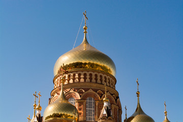 Fototapeta na wymiar The domes of the Orthodox church against the blue sky, beautiful golden