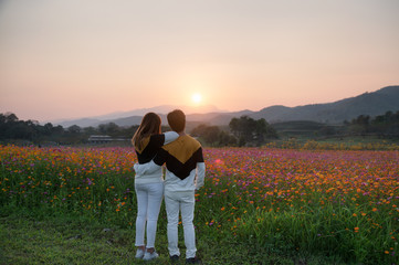 Young couple sightseeing cosmos field