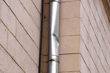 Crumpled drainpipe on the facade of the building