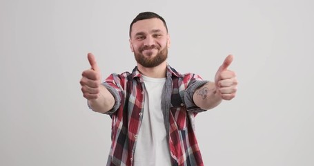Happy young man giving thumbs up with both hands