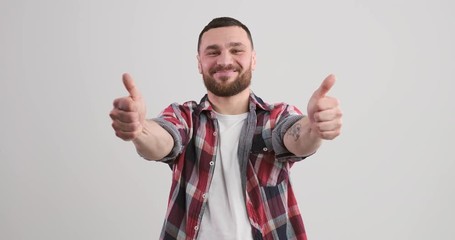 Successful young man gesturing thumbs up with both hands