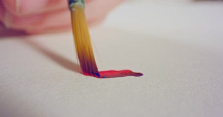 Macro shot of brush painting on paper with acrylic colors