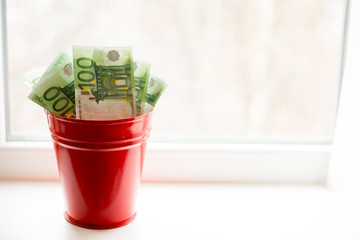 Moneybox, Euro bill in bucket on white window.light background. place for text. top view. a lot of money