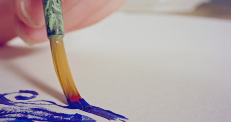 Macro shot of brush painting on paper with acrylic colors