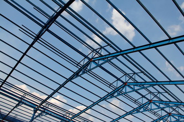 Structure of steel roof frame for building construction on sky background