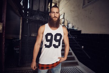 Muscular young bearded man in staircase