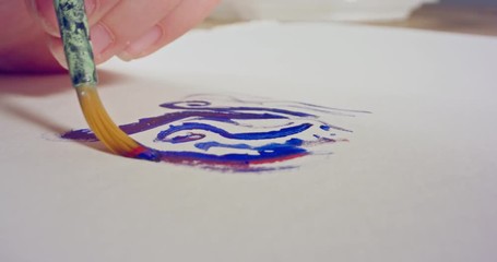 Macro shot of brush painting on paper with acrylic colors
